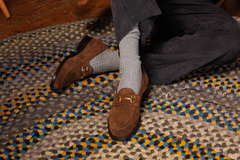 Wildsmith Model 51 snaffle-bit loafers in Brown Suede, worn with grey socks on a braided rug